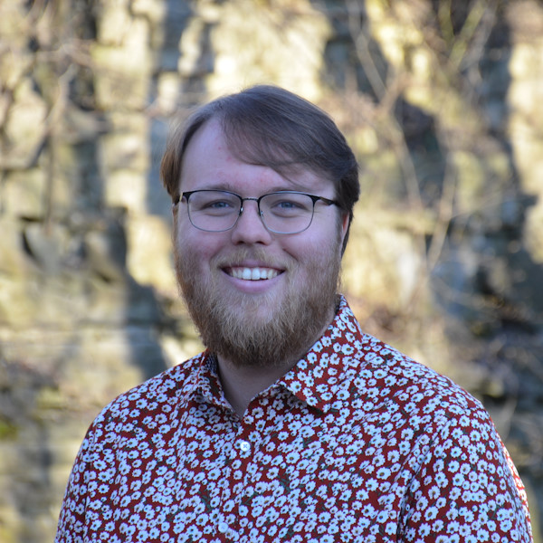 headshot of Ben in colourful shirt outdoors